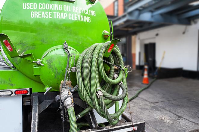 a vacuum truck pumping out a large underground grease trap in Ayer, MA