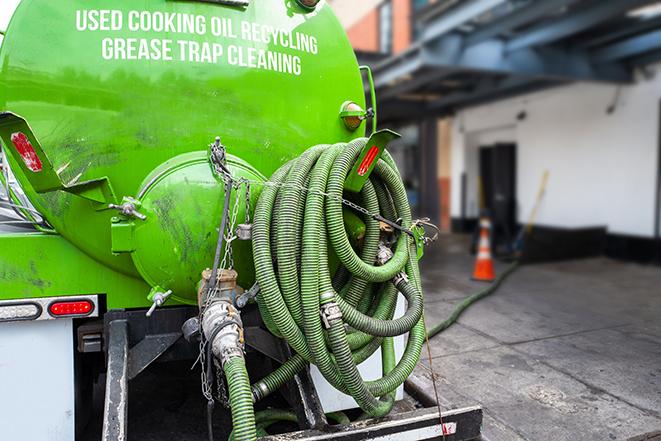 a grease trap being pumped by a sanitation technician in Concord MA